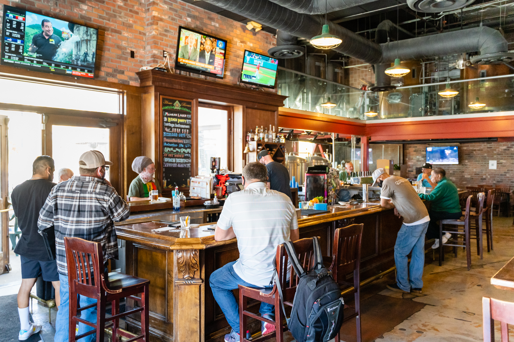 Inside the Lamppost Pizza bar with guests and TV screens